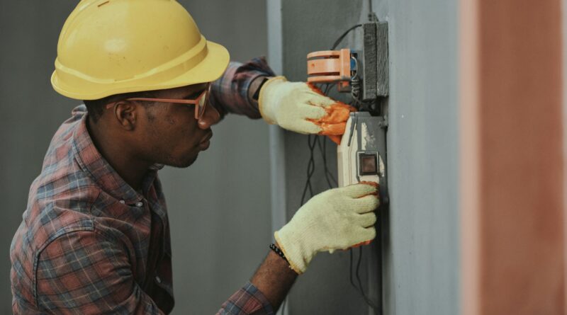 man in brown hat holding black and gray power tool